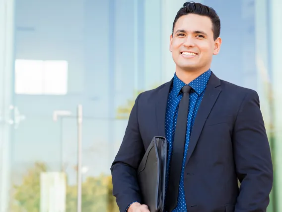 Male student in blue suit holding portfolio