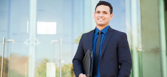 Male student in blue suit holding portfolio